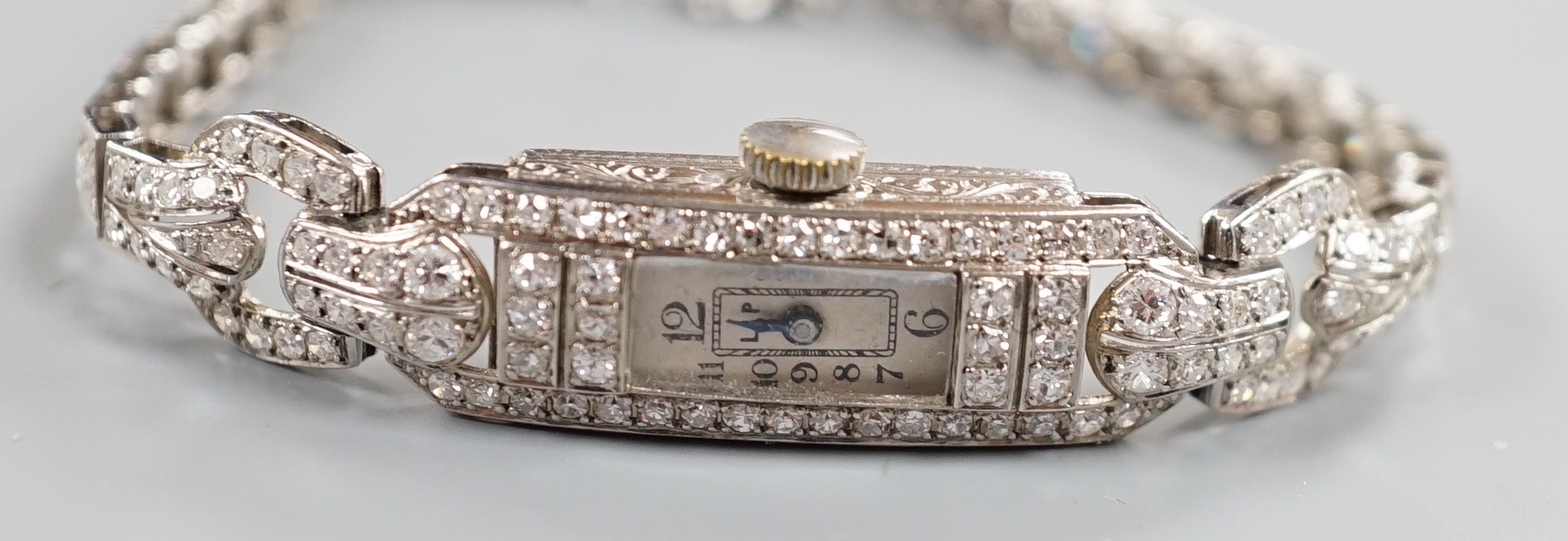 A lady's white metal and diamond set rectangular dial manual wind cocktail watch, with diamond set bracelet, cased diameter 11mm, gross weight 20.5 grams, with two spare links.